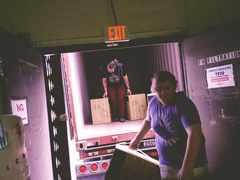 Rachel & Amby unloading the container. Stu's inside stacking them in place.